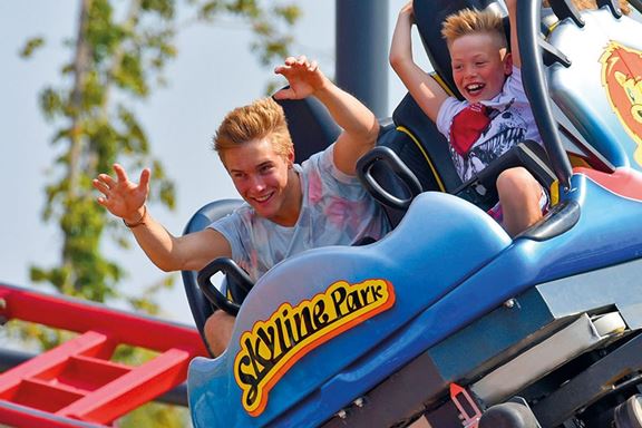 Zwei Kinder sitzen im Waggon einer Achterbahn